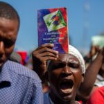 manifestant-brandit-copie-constitution-haitienned-manifestationexiger-demission-president-haitien-Jovenel-Moise-Port-Prince-Haiti-mercredi-10-fevrier-2021_0_1400_963.jpg